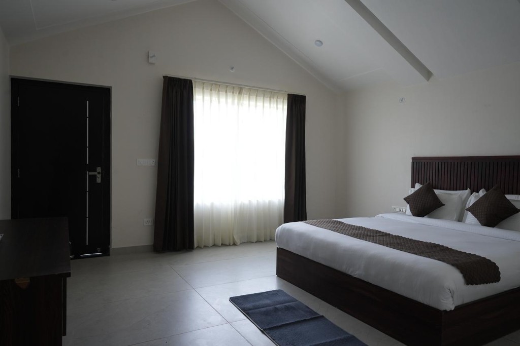 Guest suite bedroom with striped bedding and panelled wall